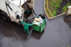 Aerial shot of a refuse collection lorry and two operatives emptying a commercial bin