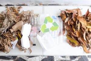A collection of dry mixed recycling items - plastic, cardboard - and a recycling symbol